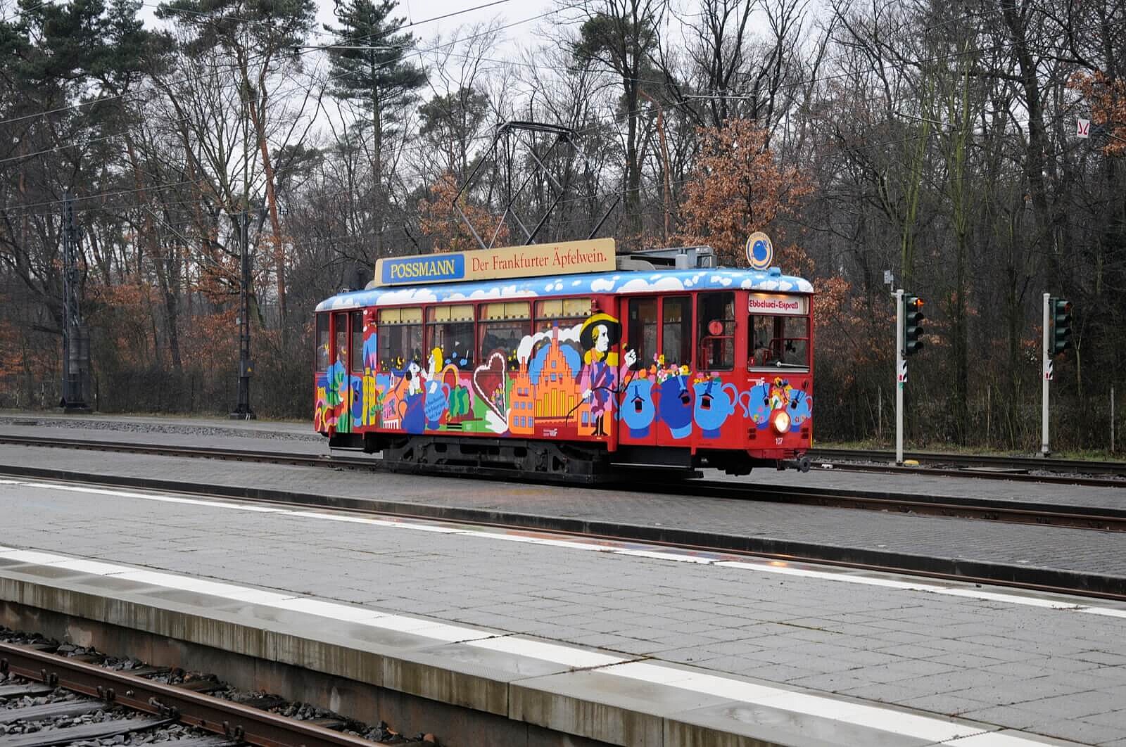 Ebbelwei-Express Wagon an der Station Station mit Bäumen im Hintergrund.