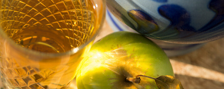 Nahaufnahme Ebbelweikruf, Glas voll mit Ebbelwei und einem grünen Apfel.