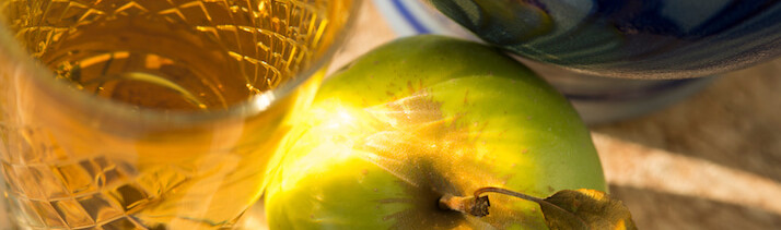 Nahaufnahme Ebbelweikruf, Glas voll mit Ebbelwei und einem grünen Apfel.